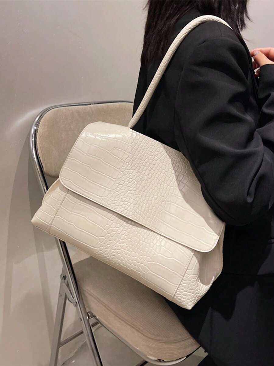 Varelle Croc-Embossed Satchel in beige, worn on the shoulder
