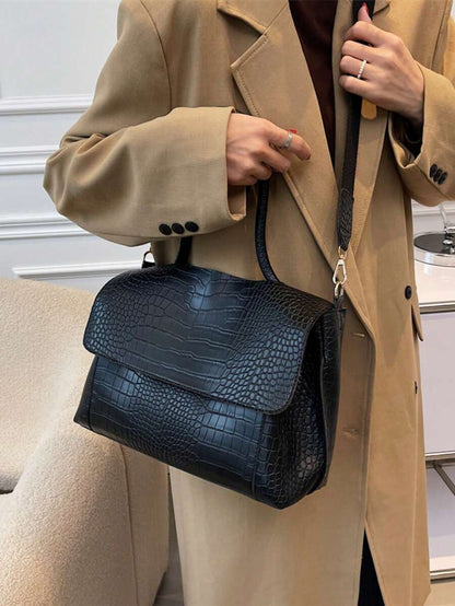 Varelle Croc-Embossed Satchel in black, carried by the handle