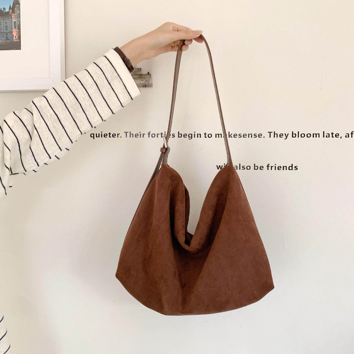 Sloane Suede Hobo Bag in brown, held by the strap