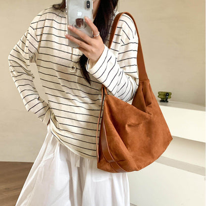 Sloane Suede Hobo Bag in tan, worn on the shoulder