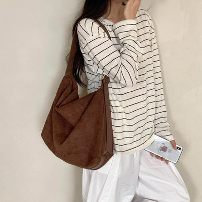 Sloane Suede Hobo Bag in dark brown, worn on the shoulder