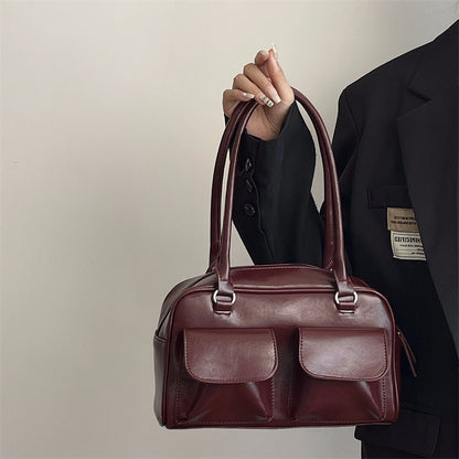 Romy Glossy Pocket Bag in wine red, held by hand