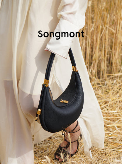 Aria Leather Crescent Bag in black, carried by hand